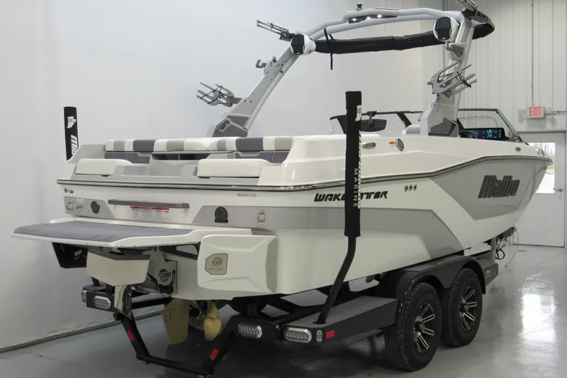 Slide: The Image of 2026 Malibu Wakesetter 21 LX boat on trailer in indoor showroom. - 2