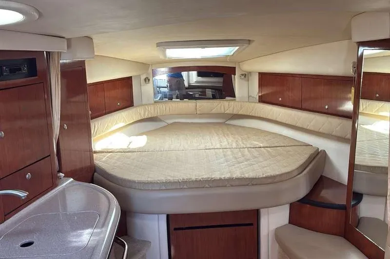 Slide: The Image of 2006 Sea Ray 340 Sundancer cabin interior with bed, wood cabinetry, and skylight. - 7