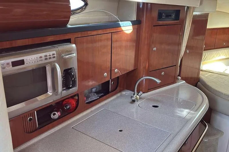 Slide: The Image of 2006 Sea Ray 340 Sundancer interior kitchen with wood cabinets and modern appliances. - 8