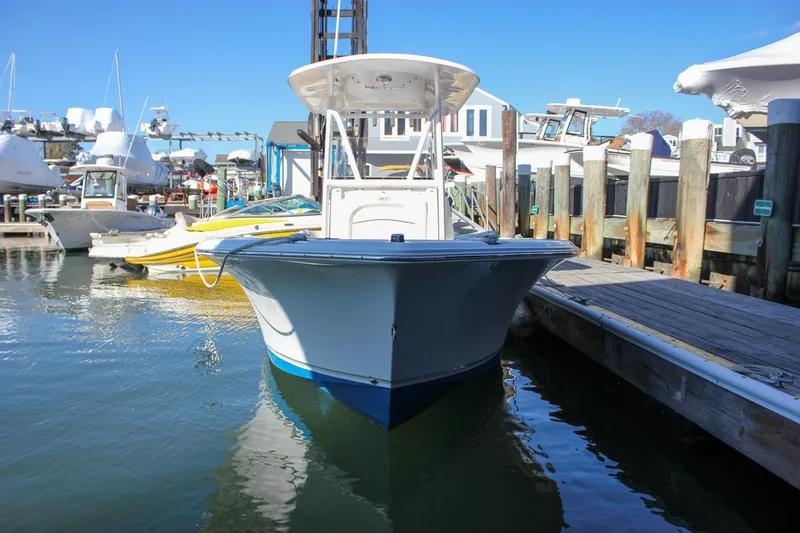 Slide: The Image of 2020 Sea Hunt Ultra 234 boat docked at a marina on a sunny day. - 4