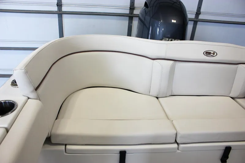 Slide: The Image of 2020 Sea Hunt Ultra 234 boat interior with white cushioned seating and cup holders. - 45