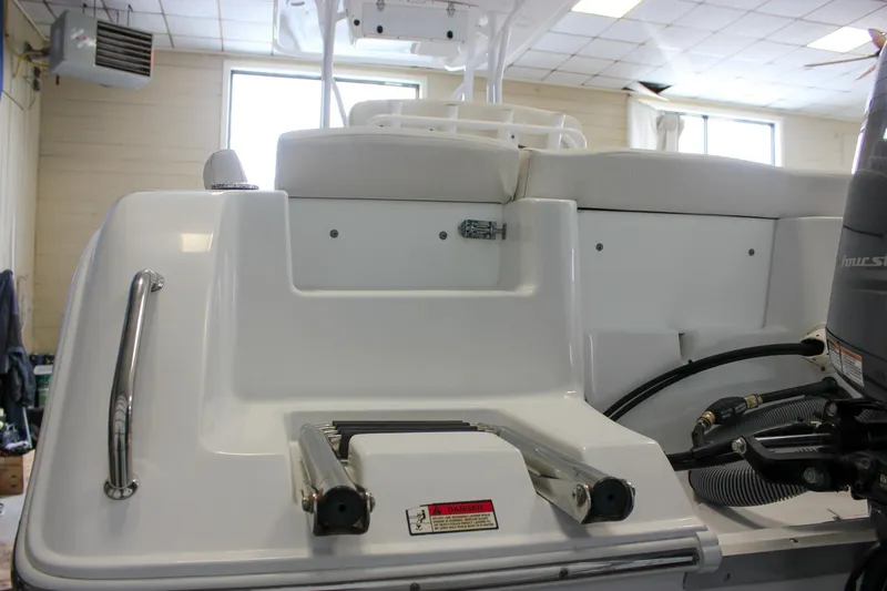 Slide: The Image of 2020 Sea Hunt Ultra 234 boat interior with ladder and seating in a well-lit showroom. - 48