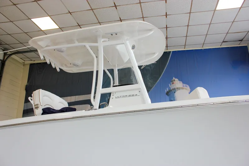 Slide: The Image of 2020 Sea Hunt Ultra 234 boat in showroom, featuring T-top and seating. - 52