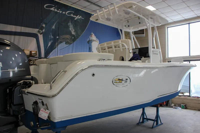 Slide: The Image of 2020 Sea Hunt Ultra 234 boat in showroom, featuring sleek design and powerful engine. - 53