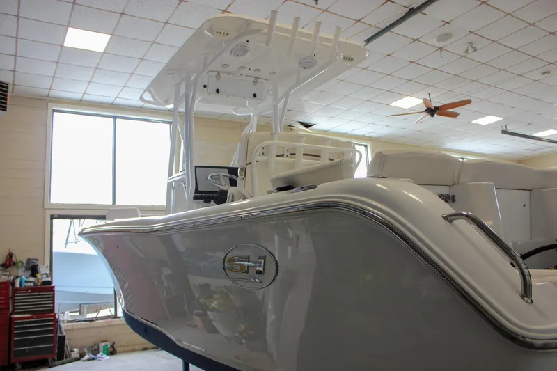 Slide: The Image of 2020 Sea Hunt Ultra 234 boat in a showroom, showcasing sleek design and modern features. - 55