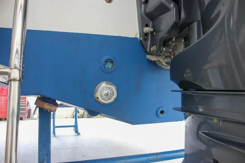 Slide: The Image of 2020 Sea Hunt Ultra 234 boat hull and motor detail in a workshop setting. - 57