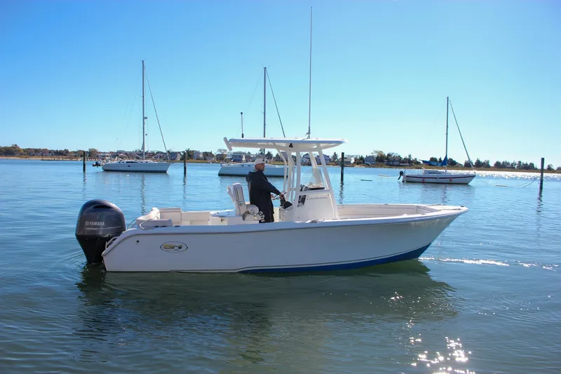 Slide: The Image of 2020 Sea Hunt Ultra 234 boat on calm water with a Yamaha outboard motor. - 59