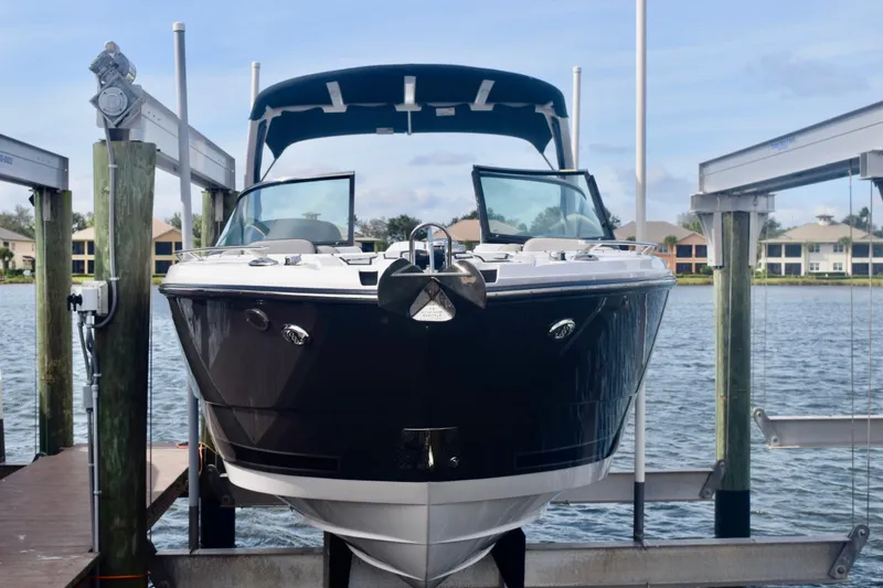 Slide: The Image of 2025 Monterey 275SS Super Sport boat docked on a lift by the water. - 17