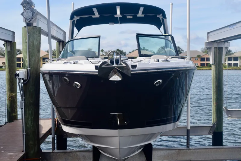 Slide: The Image of 2025 Monterey 275SS Super Sport boat docked on a lift by the water. - 18