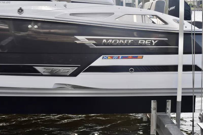Slide: The Image of 2025 Monterey 275SS Super Sport boat docked, showcasing sleek design and nautical flags. - 22