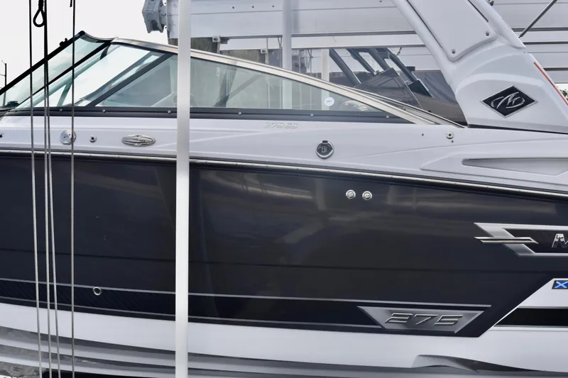 Slide: The Image of 2025 Monterey 275SS Super Sport boat, sleek black and white design, docked. - 28