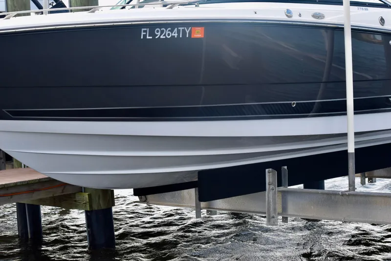 Slide: The Image of 2025 Monterey 275SS Super Sport boat docked on a lift, side view. - 31