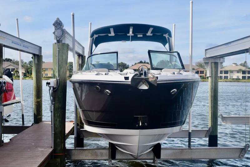 Slide: The Image of 2025 Monterey 275SS Super Sport boat docked on a lift by the water. - 4