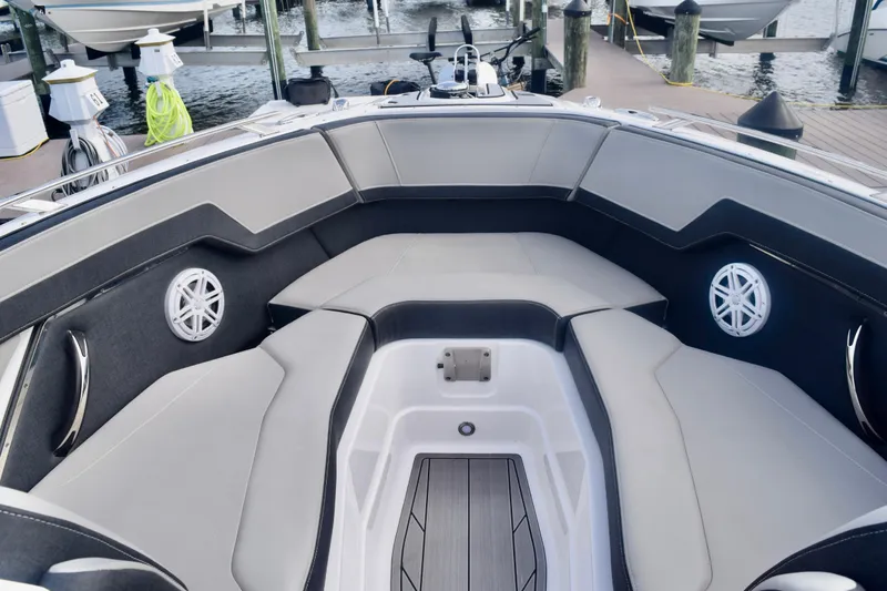 Slide: The Image of 2025 Monterey 275SS Super Sport boat interior with cushioned seating and speakers at a dock. - 74