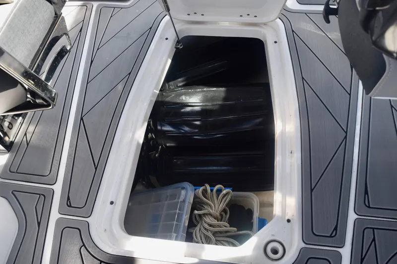 Slide: The Image of 2025 Monterey 275SS Super Sport boat storage compartment with rope and container. - 90