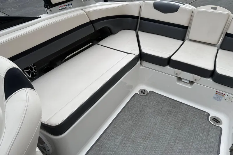 Slide: The Image of 2018 Chaparral Vortex 2430 VRX boat interior with cushioned seating and gray flooring. - 16