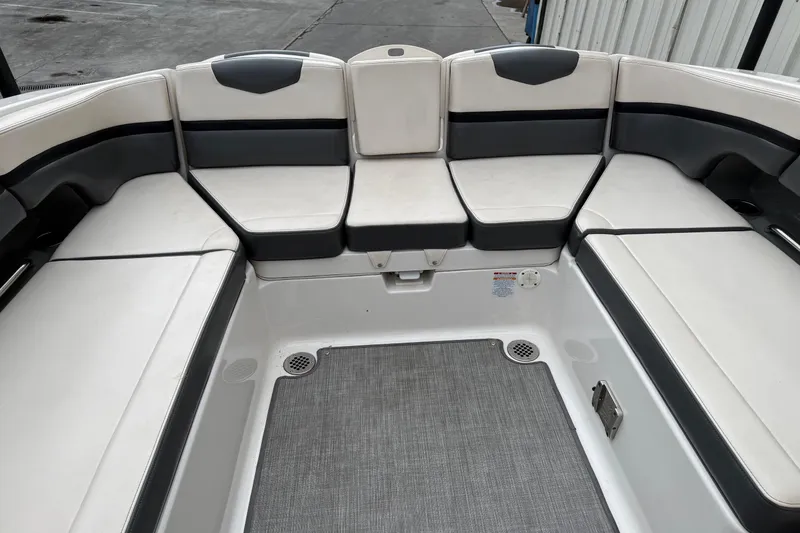 Slide: The Image of 2018 Chaparral Vortex 2430 VRX boat interior with cushioned seating and gray flooring. - 18