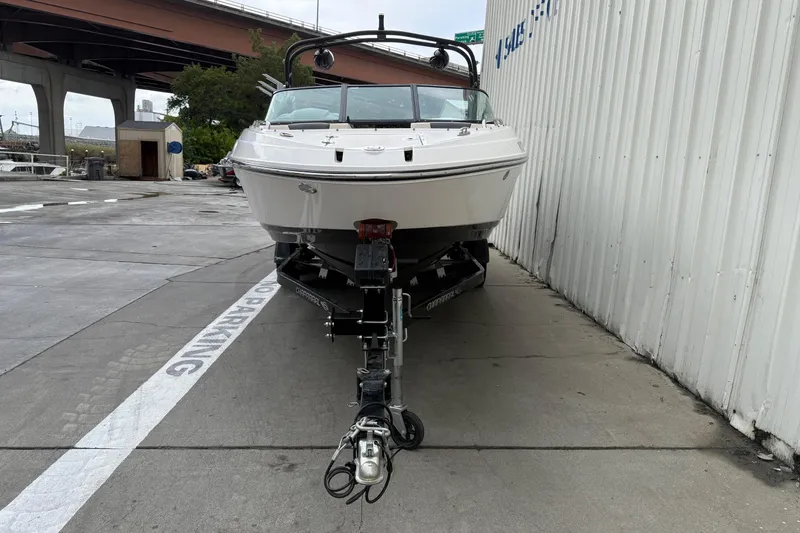 Slide: The Image of 2018 Chaparral Vortex 2430 VRX boat on trailer, parked near a building. - 2