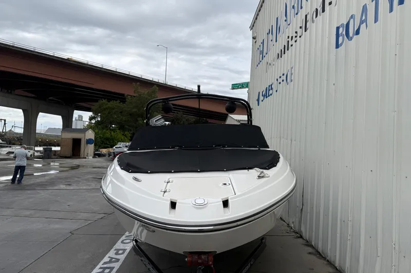 Slide: The Image of 2018 Chaparral Vortex 2430 VRX boat parked near a marina under cloudy skies. - 9