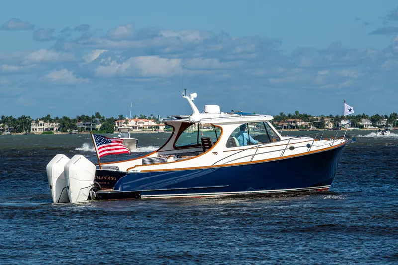 Slide: The Image of 2024 Hinckley 35 boat cruising on water with American flag, clear sky background. - 11