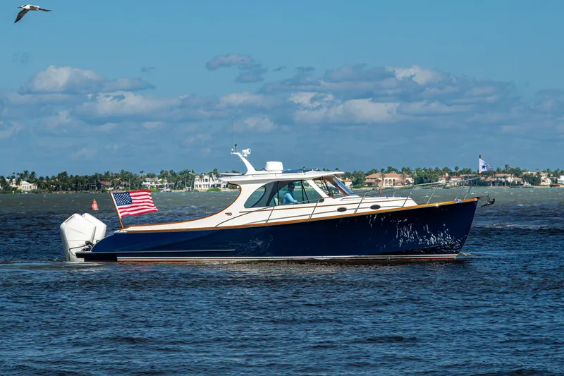 Slide: The Image of 2024 Hinckley 35 boat cruising on open water with American flag. - 13