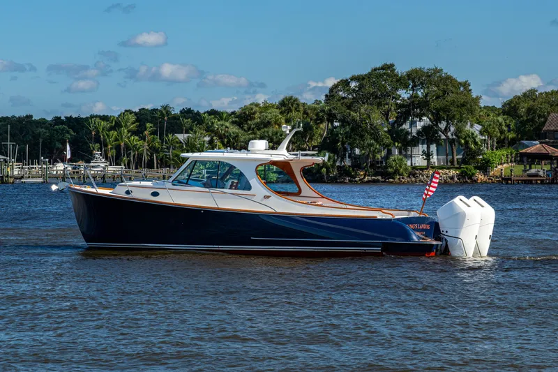 Slide: The Image of 2024 Hinckley 35 boat cruising on a scenic river with lush greenery. - 18