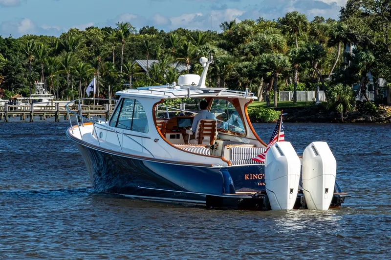 Slide: The Image of 2024 Hinckley 35 boat cruising on a scenic waterway with lush greenery. - 20