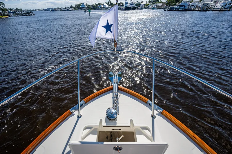 Slide: The Image of 2024 Hinckley 35 boat bow with flag, cruising on a sunny day. - 23