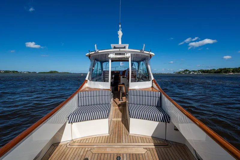 Slide: The Image of 2024 Hinckley 35 yacht on open water, featuring striped seating and wooden deck. - 26
