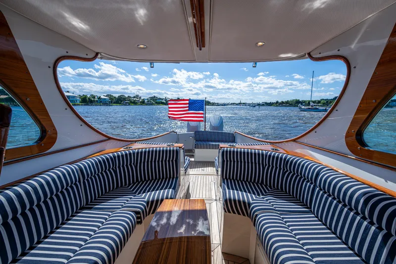Slide: The Image of Luxurious 2024 Hinckley 35 yacht interior with striped seating, overlooking scenic waterfront. - 29