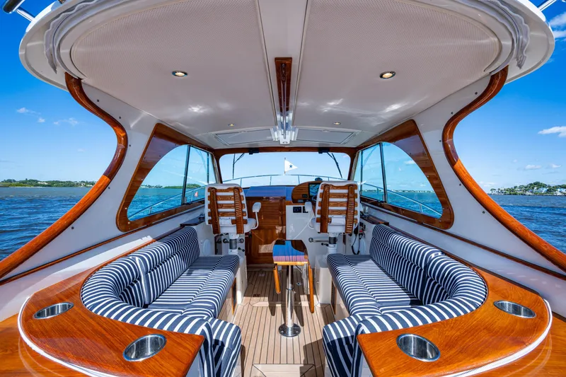 Slide: The Image of 2024 Hinckley 35 yacht interior with striped seating, wooden accents, and ocean view. - 32