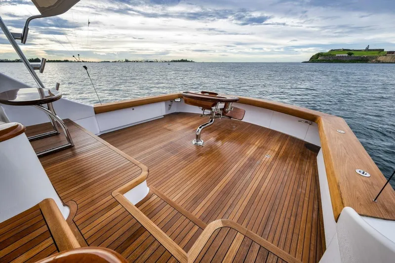Slide: The Image of Luxurious Weaver custom yacht deck with wooden finish, overlooking serene waters, 2012 model. - 34