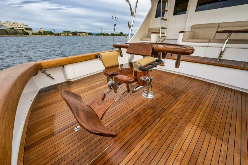 Slide: The Image of Luxurious Weaver custom yacht deck with wooden flooring, fishing chair, and scenic waterfront view. - 36