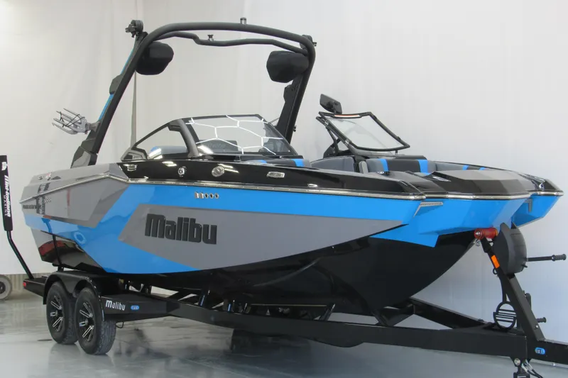 Slide: The Image of 2026 Malibu Wakesetter 22 MXZ boat in blue and gray on trailer, side view. - 1