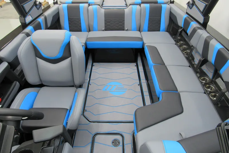 Slide: The Image of 2026 Malibu Wakesetter 22 MXZ interior with blue and gray seating, cup holders, and logo flooring. - 10