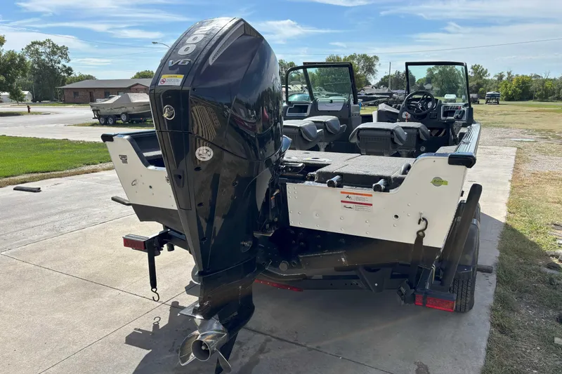 Slide: The Image of 2024 Lund 2025 Impact boat with powerful outboard motor, parked outdoors. - 3