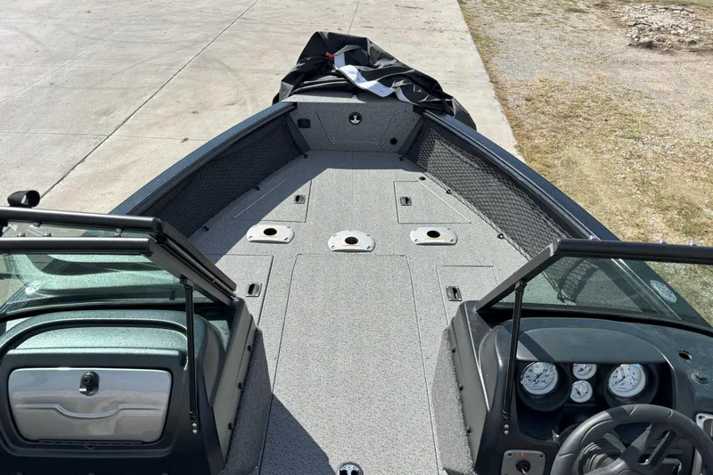 Slide: The Image of 2024 Lund 2025 Impact boat interior with open deck and dashboard view. - 6