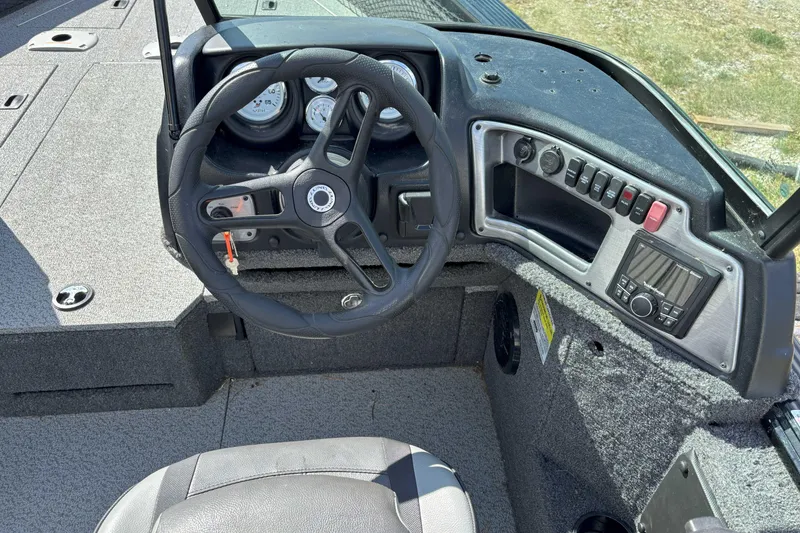 Slide: The Image of 2024 Lund 2025 Impact boat dashboard with steering wheel and control panel. - 7