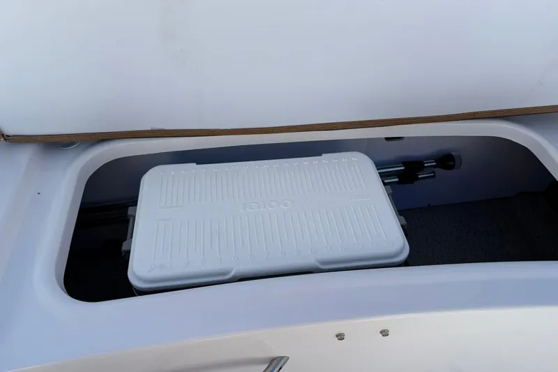 Slide: The Image of 2026 Stingray 191 DC boat storage compartment with white cooler inside. - 12