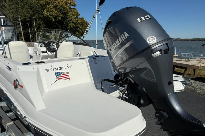 Slide: The Image of 2026 Stingray 191 DC boat with Yamaha 115 engine by a lakeside dock. - 3