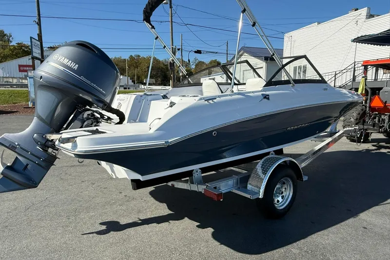 Slide: The Image of 2026 Stingray 191 DC boat on trailer with Yamaha outboard motor, parked outdoors. - 4