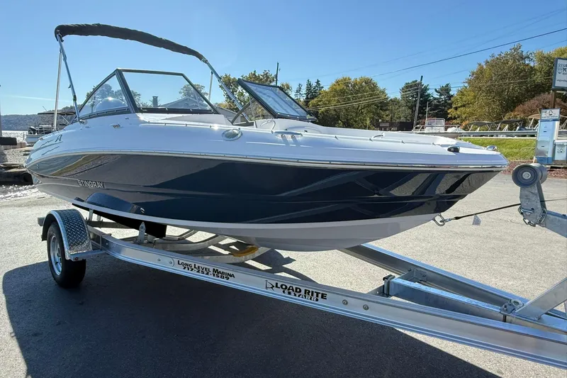 Slide: The Image of 2026 Stingray 191 DC boat on trailer, parked outdoors under clear sky. - 6