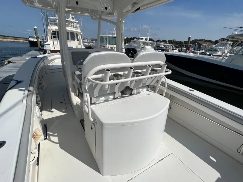 Slide: The Image of 2013 Jupiter 30 FS boat interior with seating and storage, docked at a marina. - 17