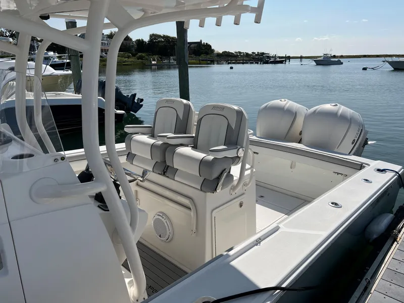 Slide: The Image of 2013 Jupiter 30 FS boat with dual engines docked in a serene marina setting. - 2