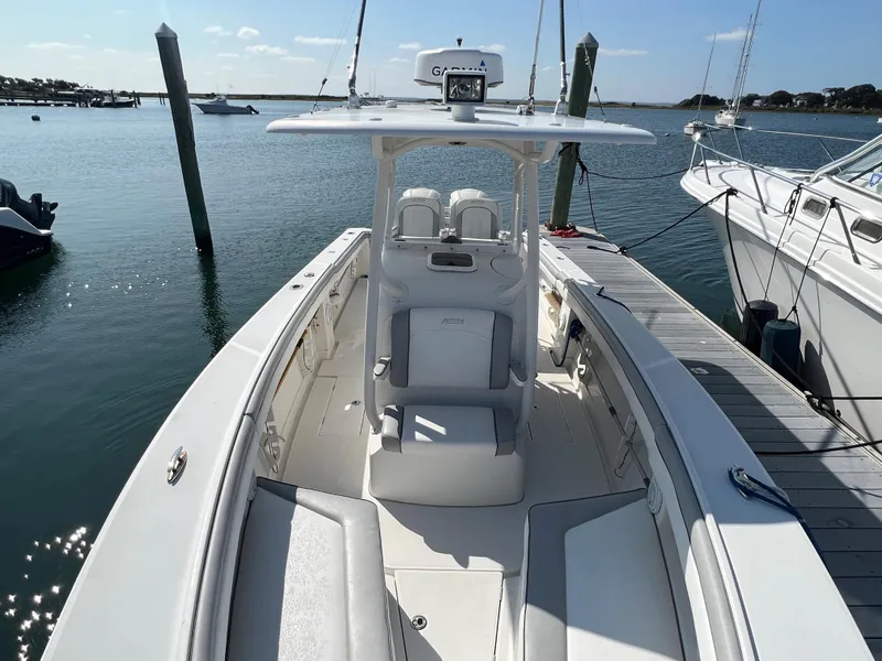 Slide: The Image of 2013 Jupiter 30 FS boat docked in a marina, featuring a sleek white design. - 23