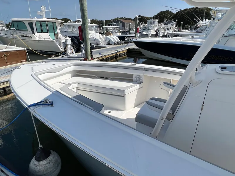 Slide: The Image of 2013 Jupiter 30 FS boat docked in a marina, featuring spacious seating and sleek design. - 24