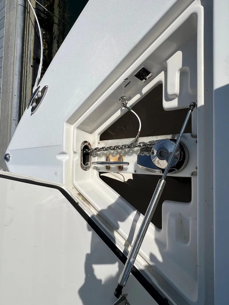 Slide: The Image of Anchor compartment of 2013 Jupiter 30 FS boat, featuring a stainless steel chain and hydraulic support. - 30
