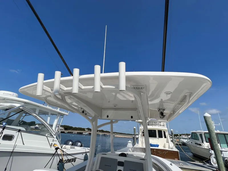 Slide: The Image of 2013 Jupiter 30 FS boat docked, featuring a white T-top and rod holders. - 35