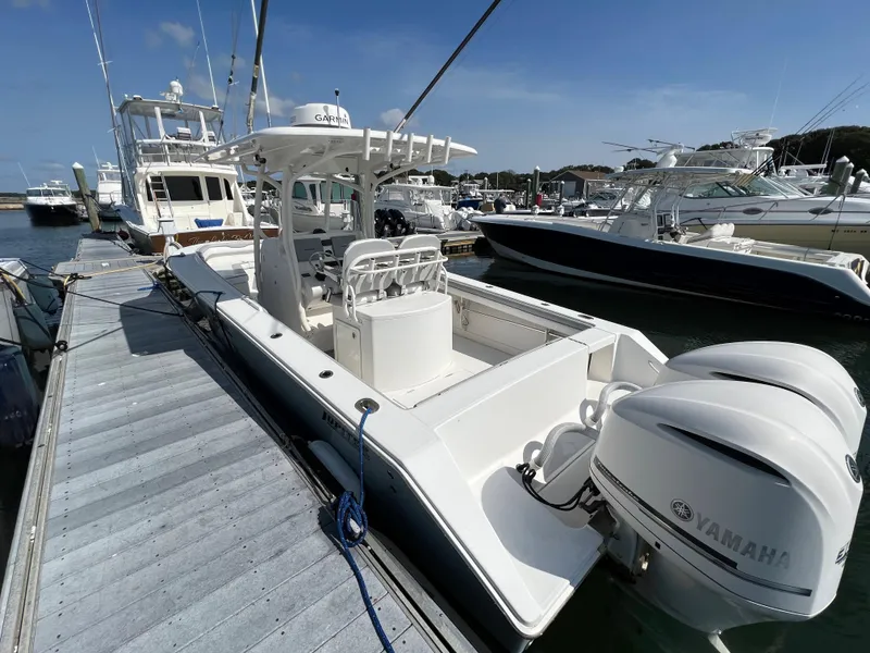 Slide: The Image of 2013 Jupiter 30 FS boat docked, featuring dual Yamaha engines, in a marina setting. - 37