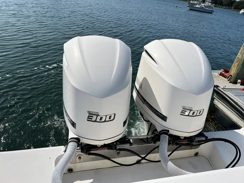 Slide: The Image of Twin Yamaha 300 outboard engines on a 2013 Jupiter 30 FS boat, docked by the water. - 44